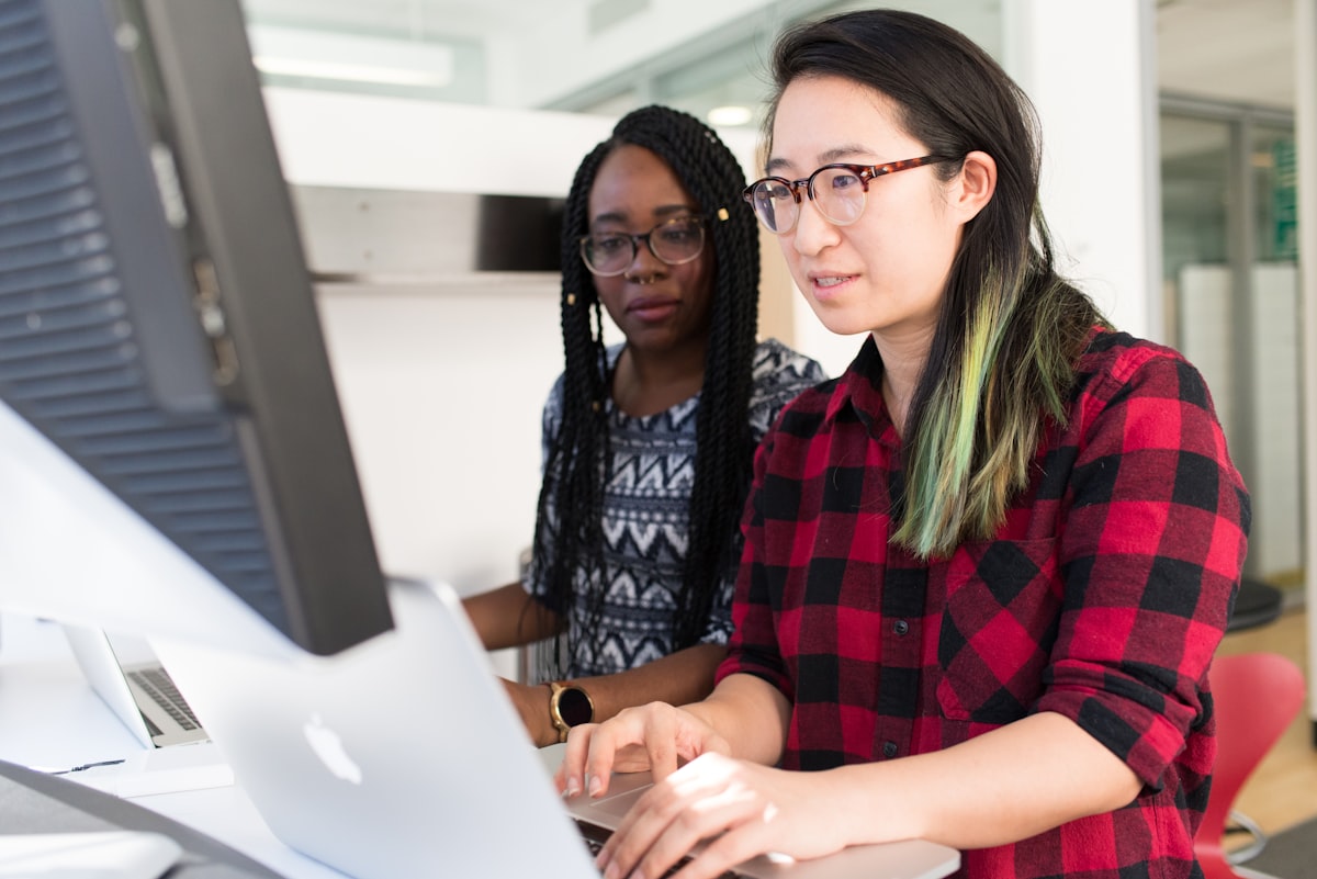 Two colleagues looking at a computer screen together