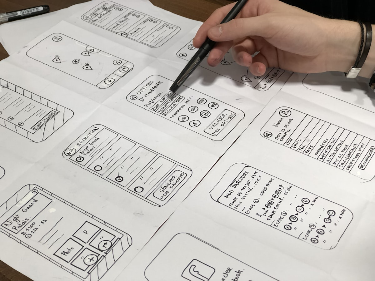 A hand sketching interface wireframes on paper